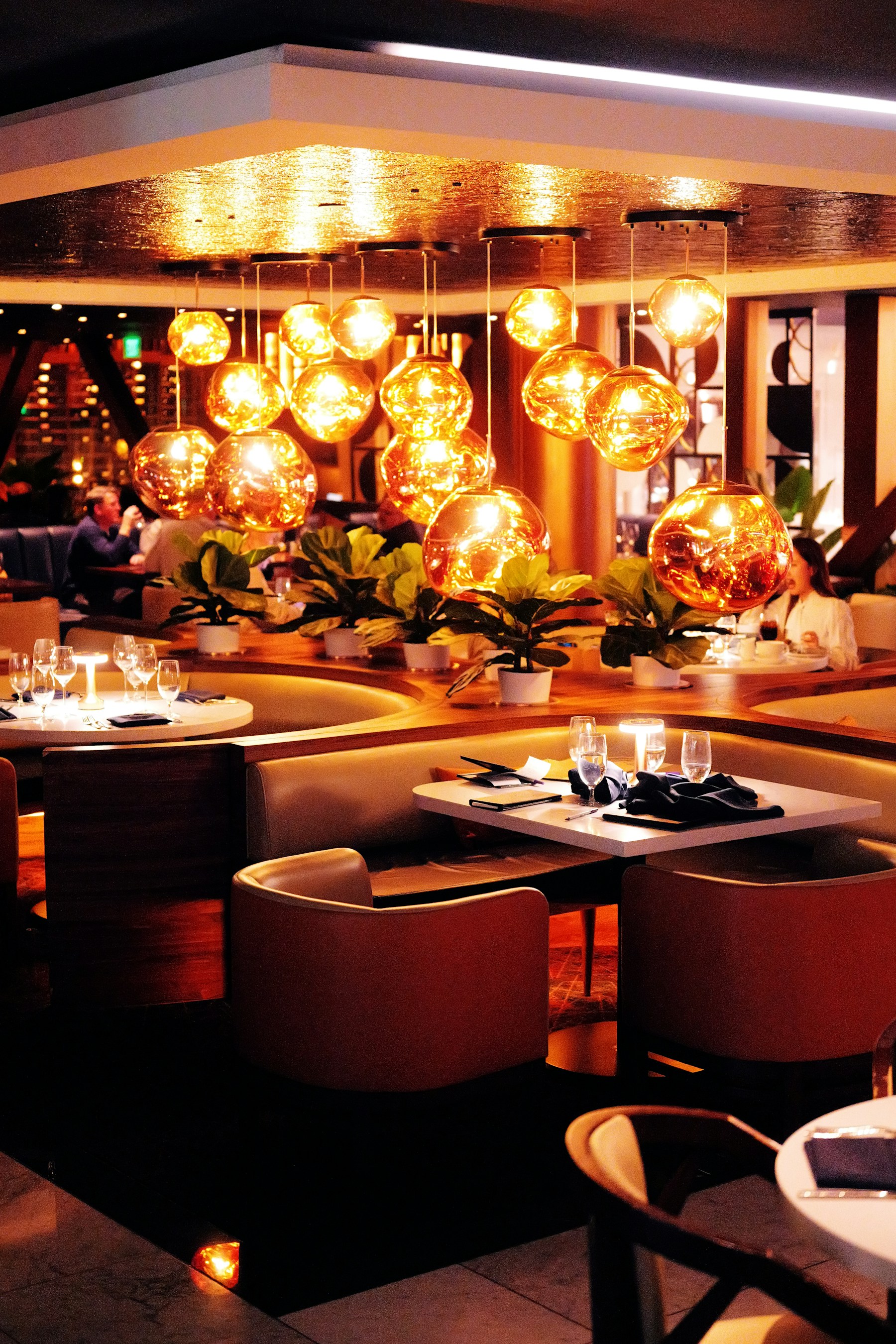 A warmly lit restaurant dining room with thoughtfully arranged tables